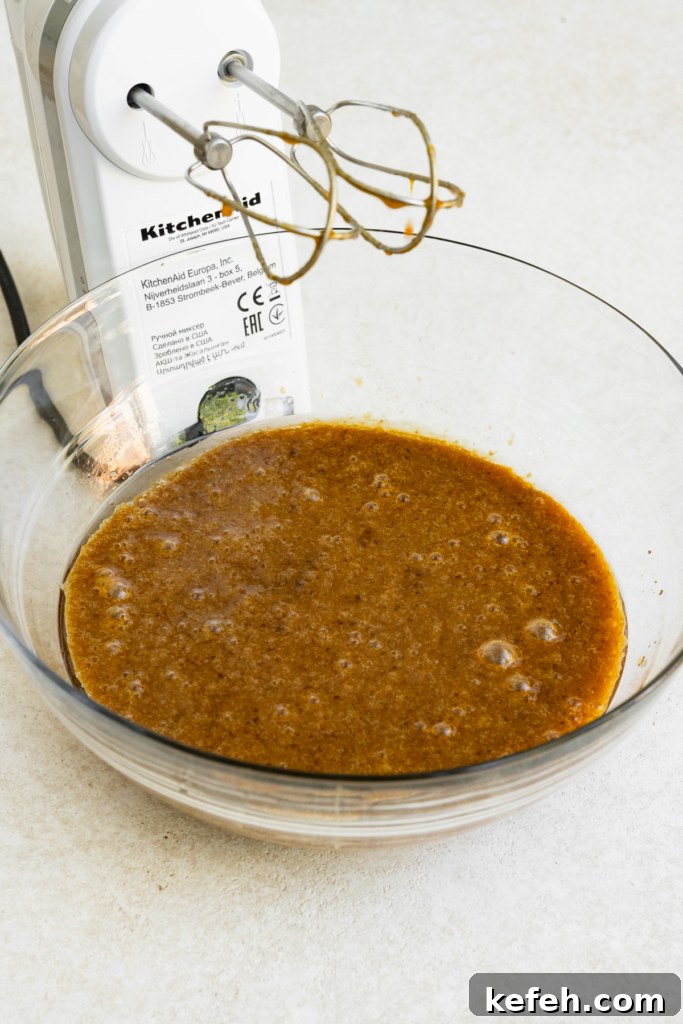 Warm Caramel Apple Spice Cake Recipe 5 Spice cake batter in a bowl next to a hand mixer.