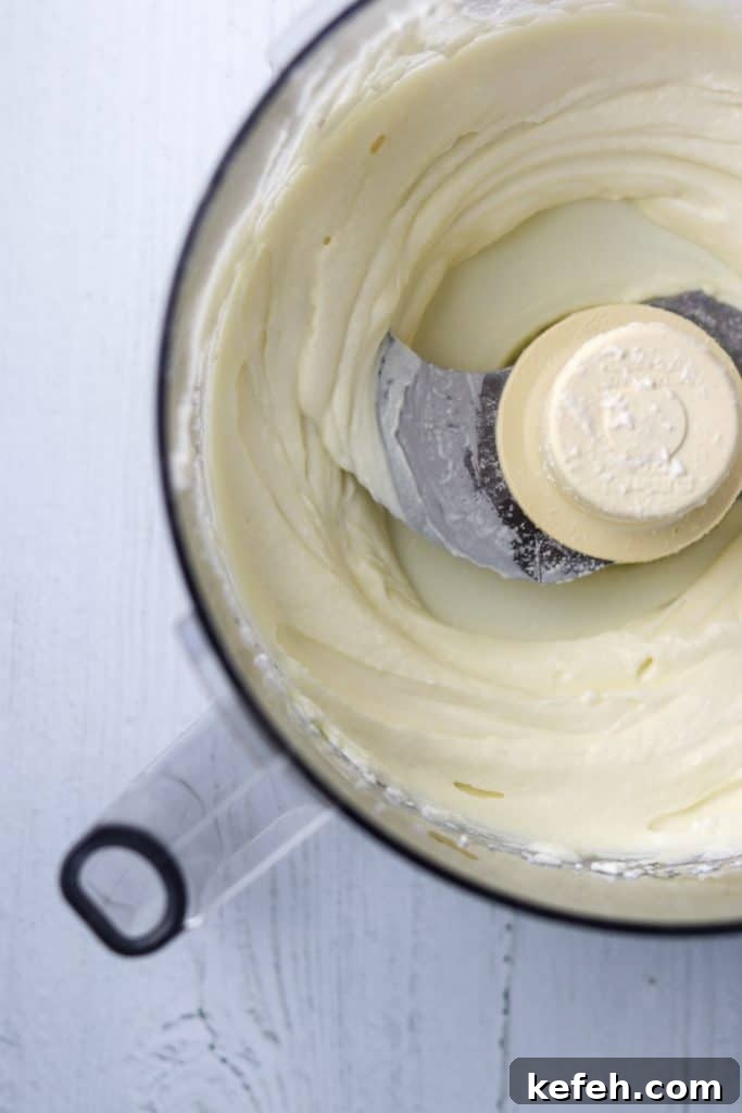 Whipped ricotta cheese in a the bowl of a food processor