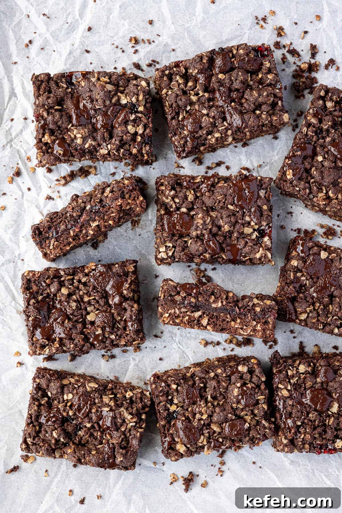Vegan chocolate raspberry crumble bars on a sheet of baking parchment.