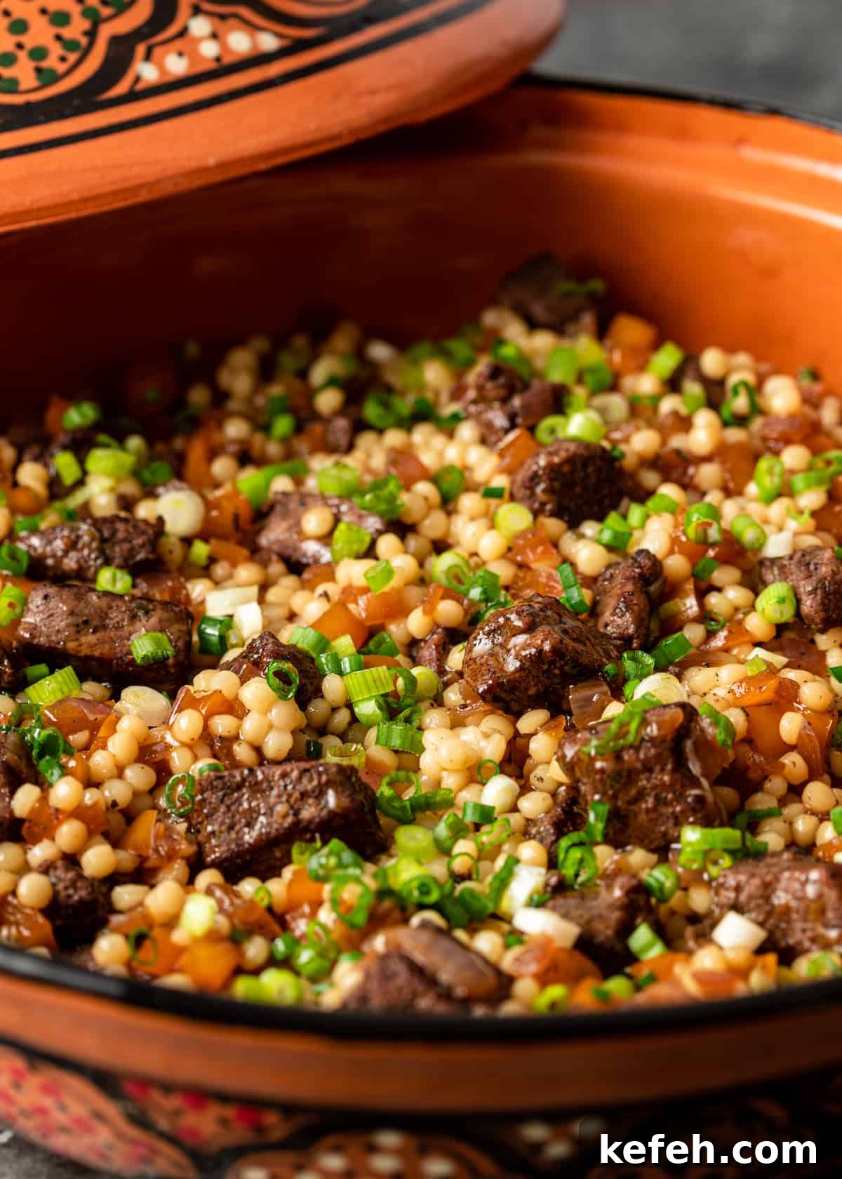 closeup side view: lamb and couscous in orange serving bowl