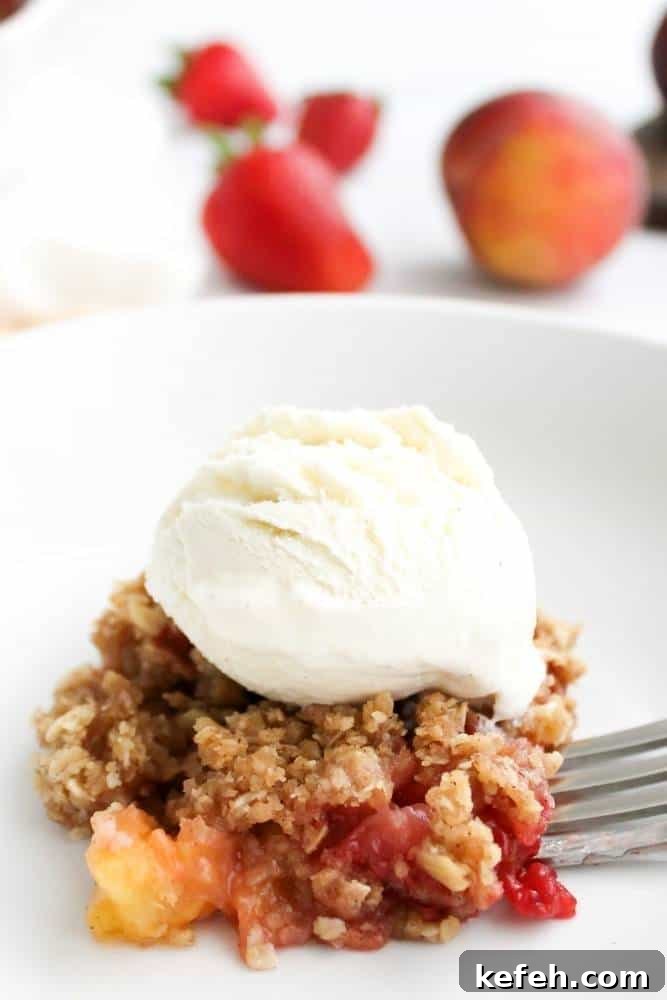 Fresh Summer Dinner Party Menu Ideas for Entertaining Guests 8 Plate of strawberry peach crisp topped with vanilla ice cream.