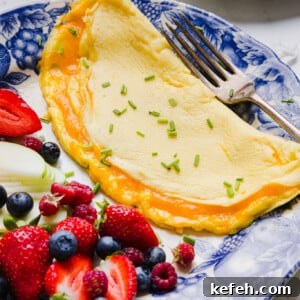 Fluffy Cottage Cheese Omelette Recipe for High-Protein Breakfast 6 A cottage cheese omelette on a plate with fresh fruit.