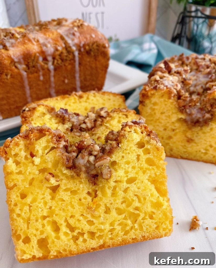 Quick Lemon Streusel Bread from Cake Mix 2 Lemon Streusel Quick Bread sliced and laying on top of each other. Larger loaf in the background.