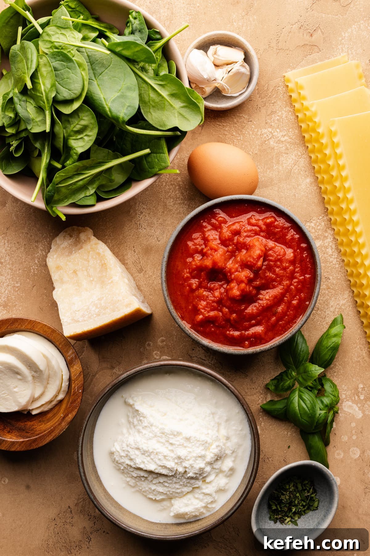 Creamy Classic Spinach Lasagna Recipe for Dinner 3 Ingredients for spinach lasagna arranged on a tan-colored background.