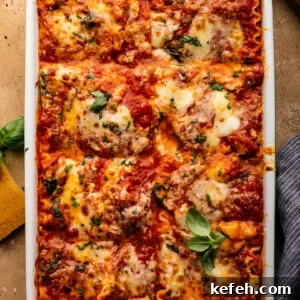 Creamy Classic Spinach Lasagna Recipe for Dinner 8 Lasagna in a white dish with green herbs sprinkled over it. The dish of lasagna is sitting on a tan colored background with a glass of white wine, a parmesan rind, and herbs arranged around it.