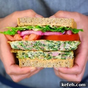 A closeup shot of someone holding a paleo St. Paul sandwich that has been sliced in half.