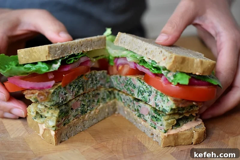 Someone holding two halves of a St. Paul sandwich with gluten-free and paleo-friendly ingredients.