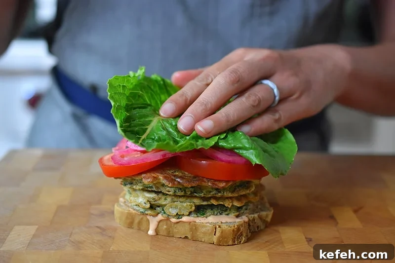 Adding a piece of lettuce on a paleo St. Paul sandwich.