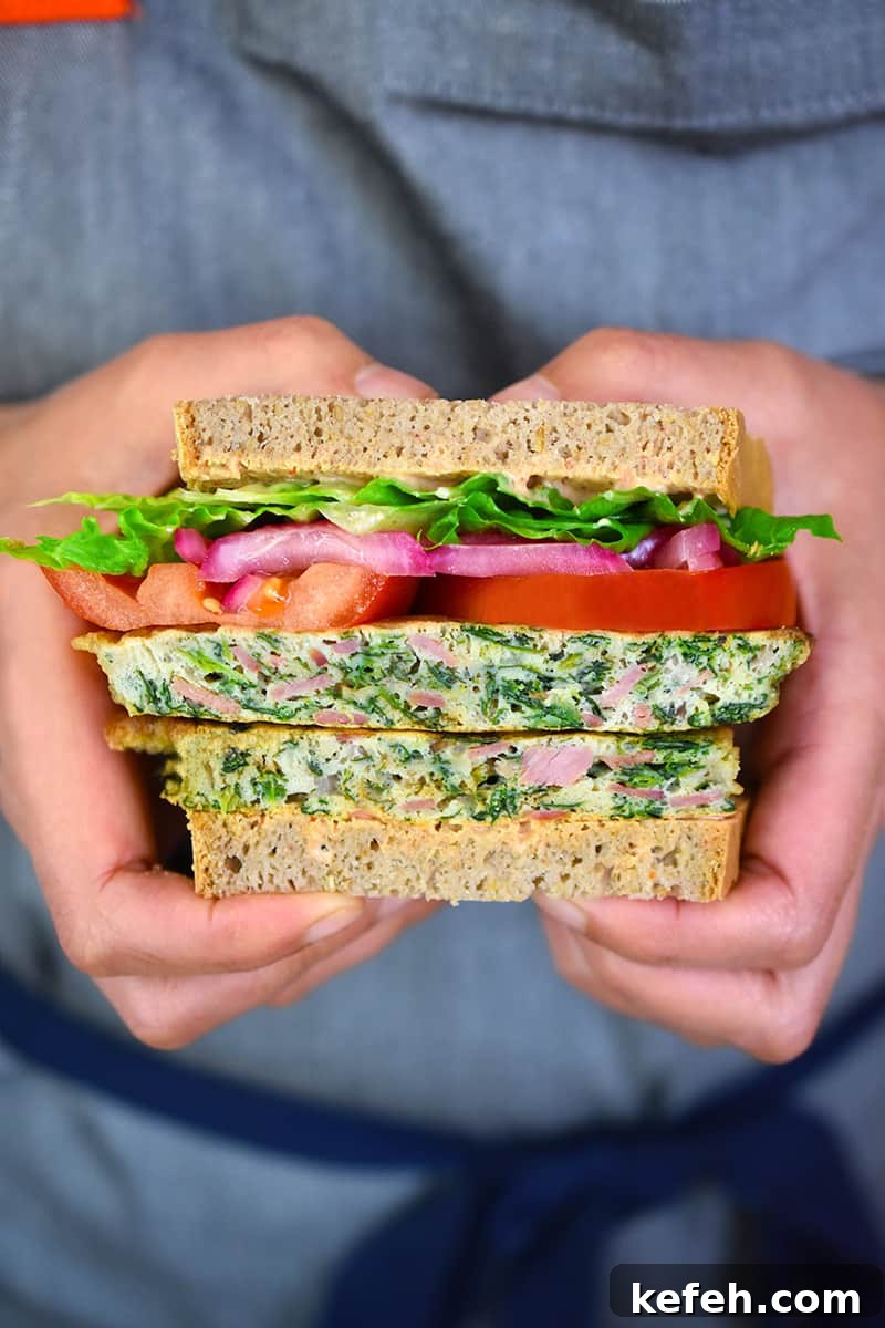 A closeup shot of someone holding a paleo St. Paul sandwich that has been sliced in half.