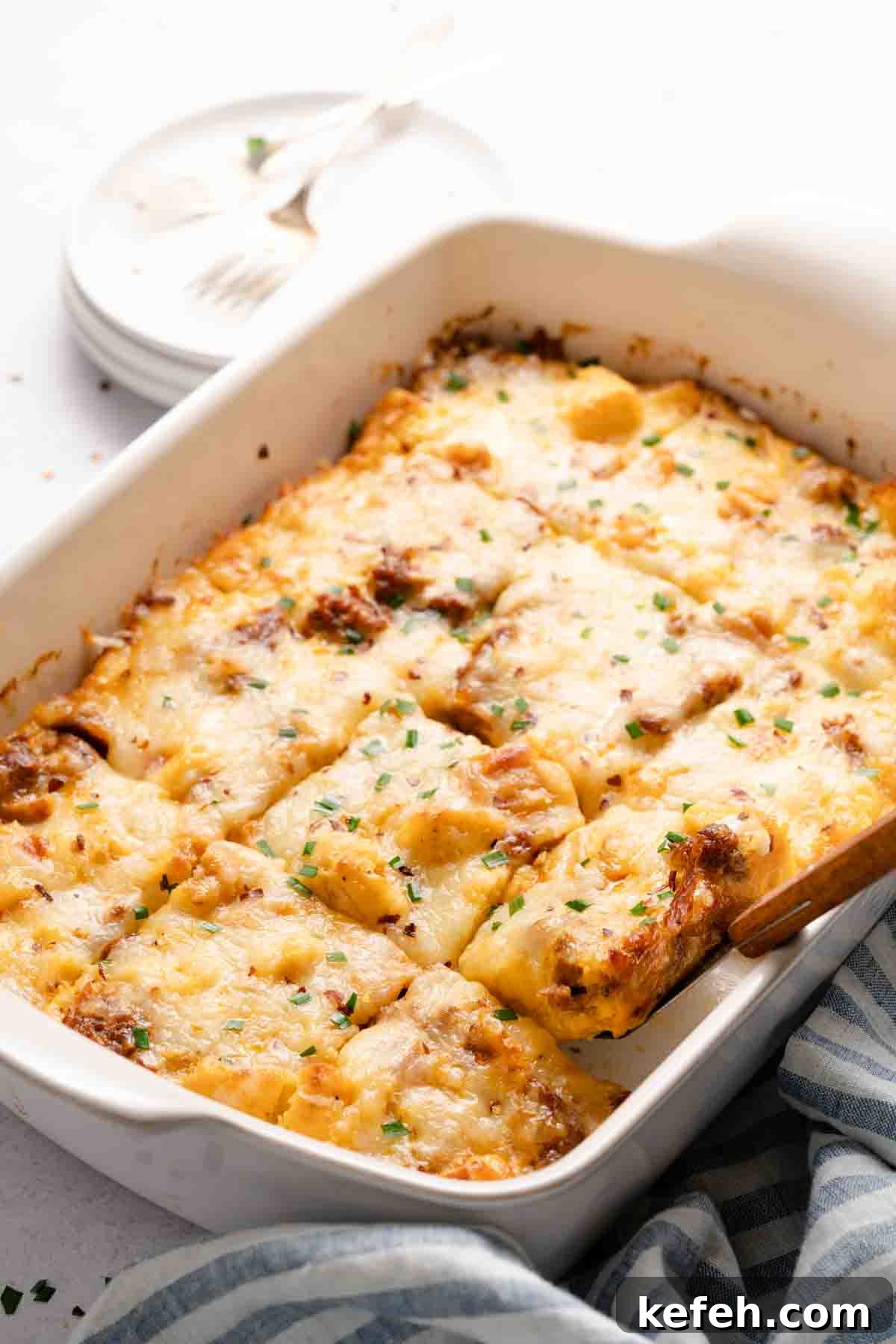 breakfast casserole in white pan with spatula lifting out a piece