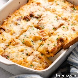 Breakfast casserole cut into squares in baking pan with spatula
