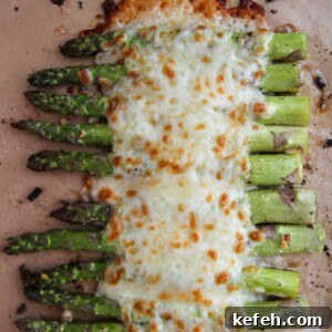 cheesy garlic asparagus on a baking sheet.