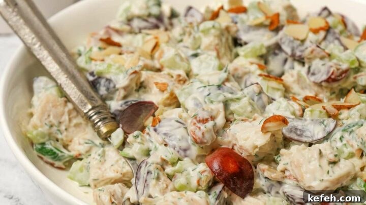 Gluten-free chicken salad in a white bowl with a serving spoon.