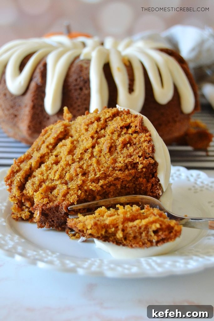 a piece of pumpkin bundt cake on its side with a fork taking a bite out of it