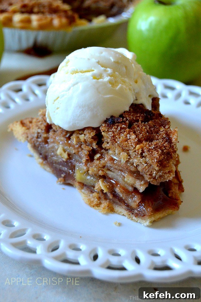 slice of apple crisp pie with a scoop of vanilla ice cream on a white lacy plate