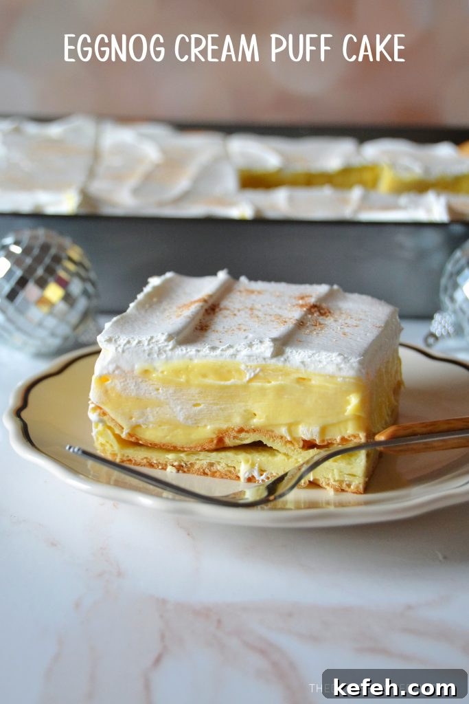 eggnog cream puff cake slice on a small white plate with a fork resting on it