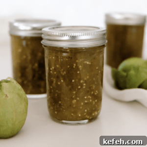 Three jars of tomatillo salsa in canning jars on countertop.