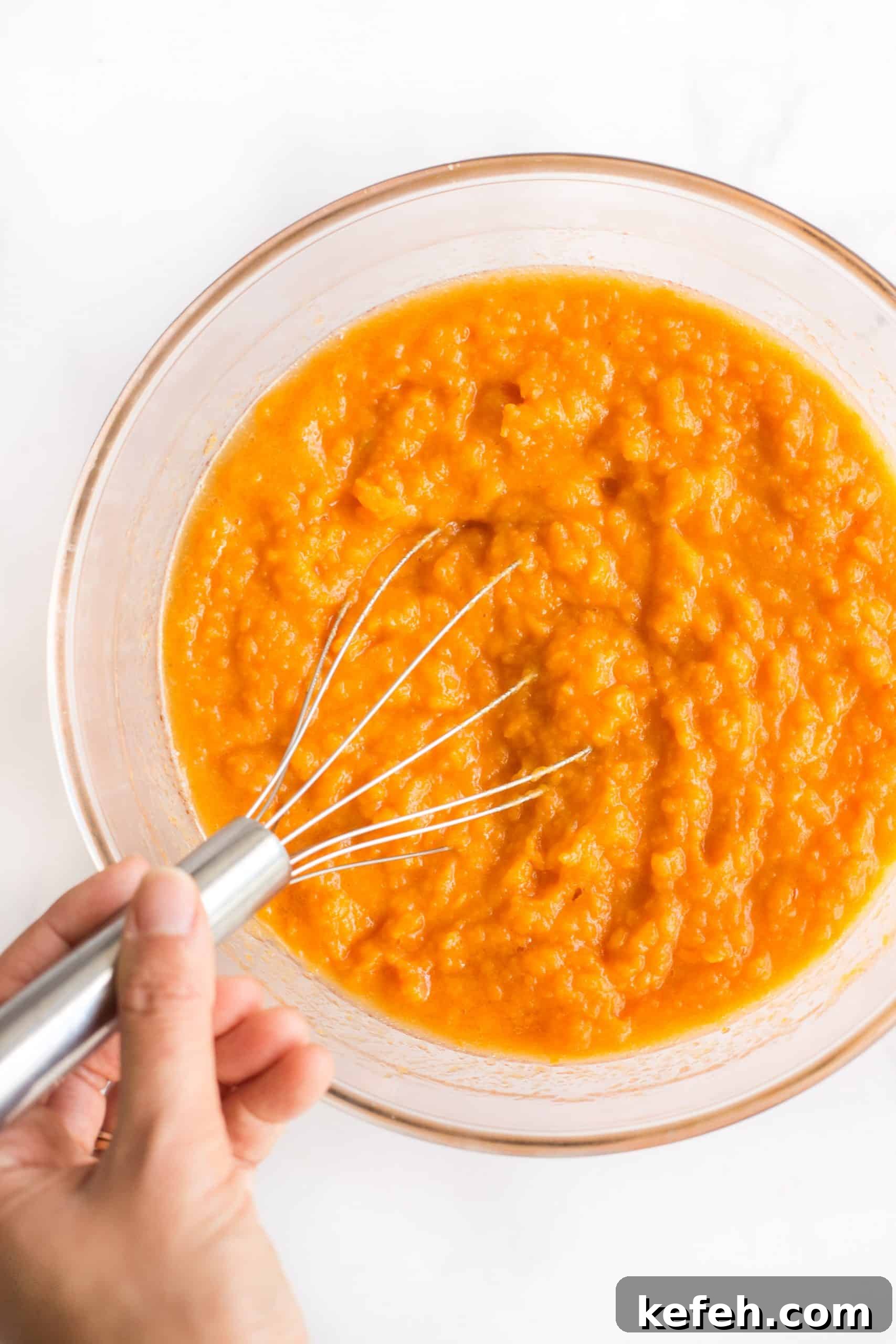 Dairy-Free Sweet Potato Casserole (Gluten-Free) Whisking mashed sweet potatoes in a large bowl.