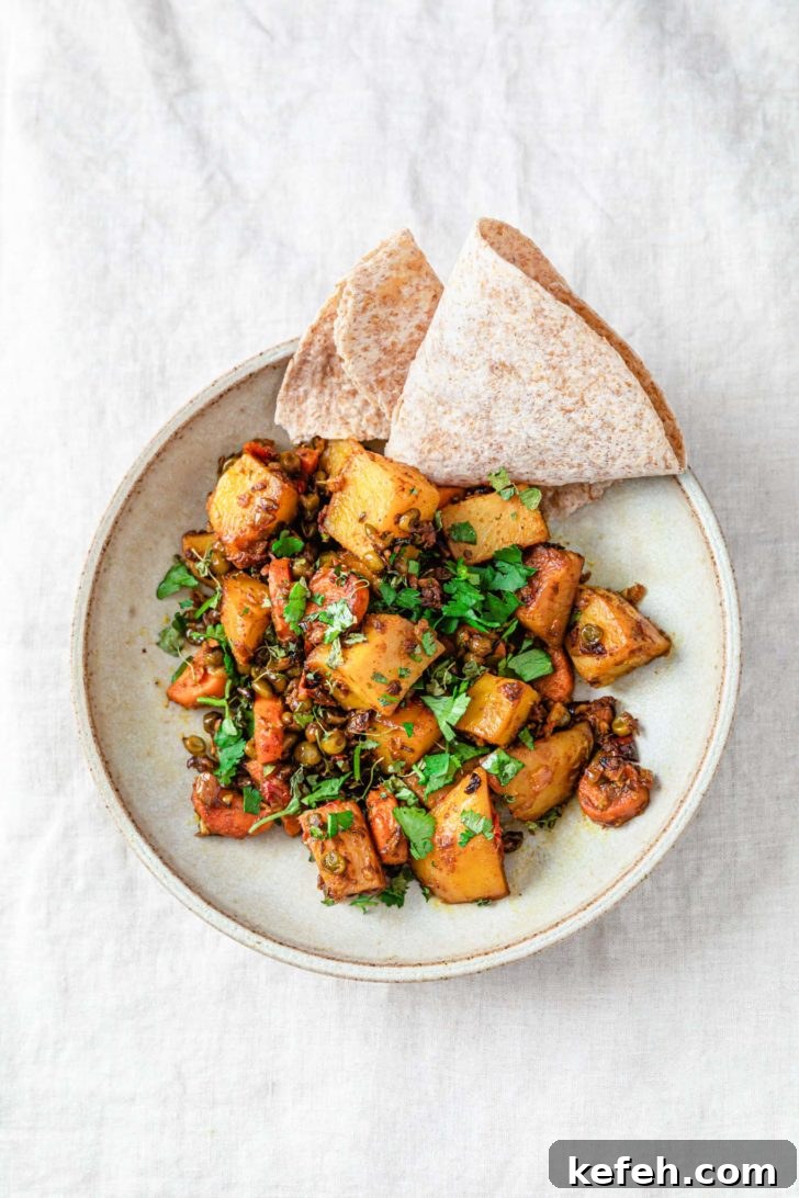 Mixed Vegetable Curry Recipe: Flavorful Indian Veggie Stew 2 Mixed vegetable curry with potatoes, carrots, and peas in a bowl sprinkled with cilantro and served with roti.