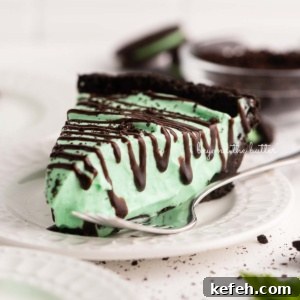Creamy No-Bake Mint Chocolate Pie Recipe 10 Dessert plates with slices of no bake mint chocolate pie with chocolate syrup drizzled over the top.