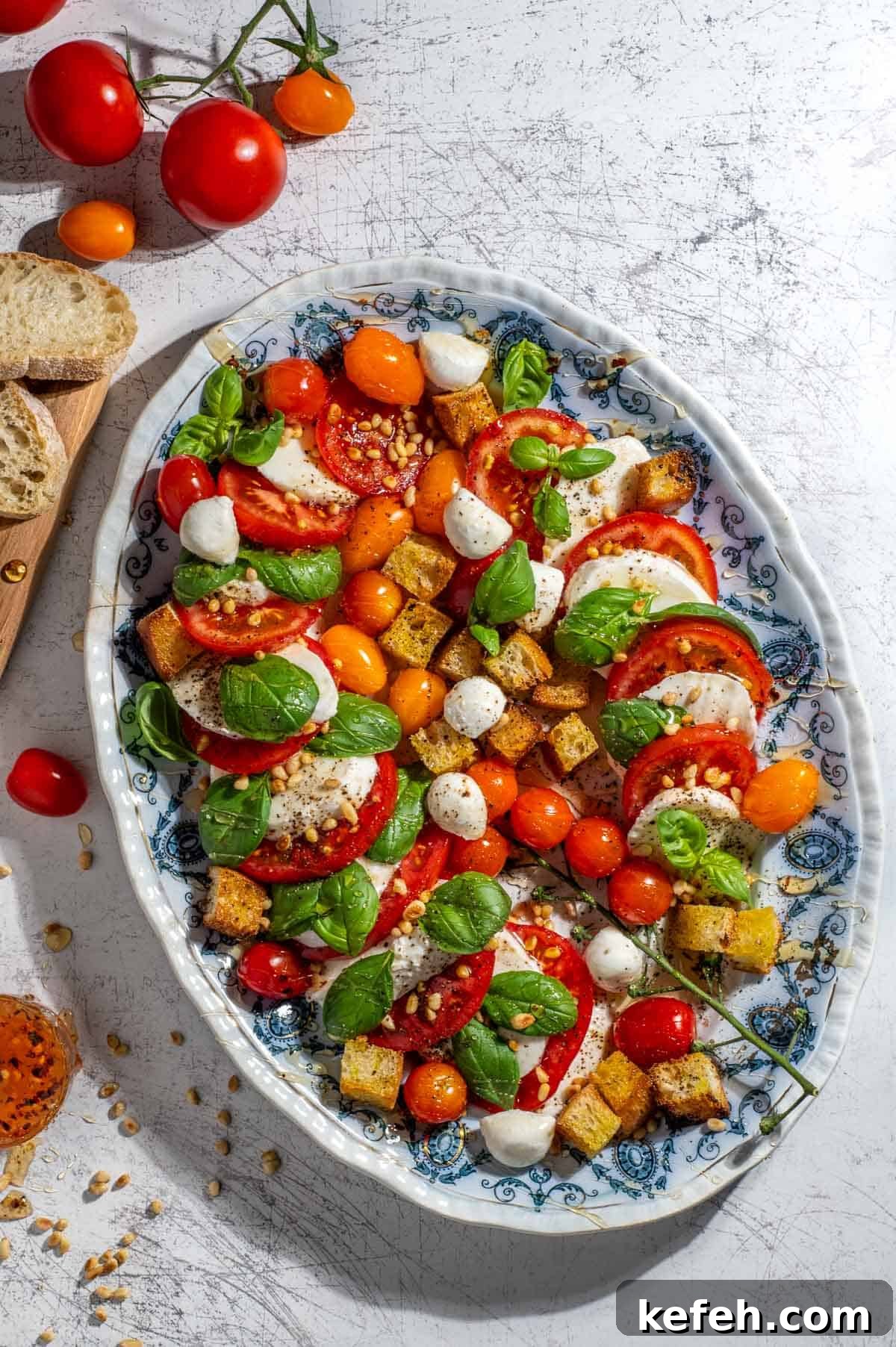 Caprese salad with hot honey dressing on a large oval plate.