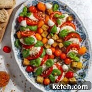 Caprese salad with hot honey dressing on a large oval plate.