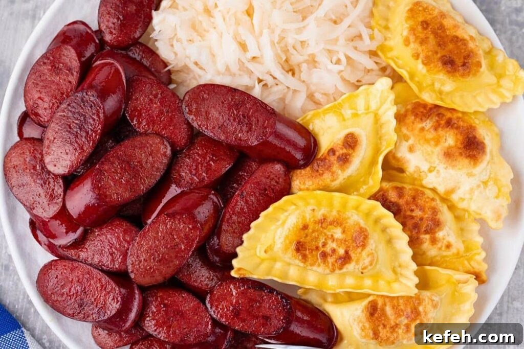 Crispy Juicy Air Fryer Kielbasa Recipe That Melts in Your Mouth 8 overhead view of air fryer kielbasa on a plate with pierogies and sauerkraut