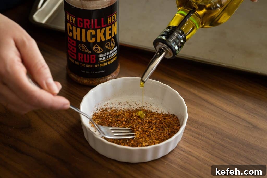 Olive oil and Hey Grill Hey Chicken Rub being mixed together in a small bowl.