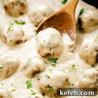 Vegan Swedish meatballs in skillet with wooden spoon, garnished with parsley
