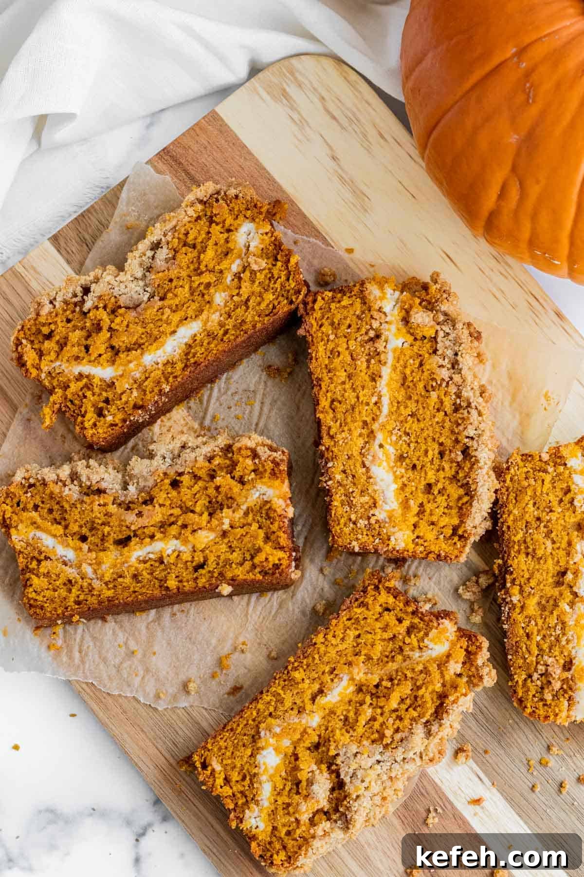slices of pumpkin cream cheese bread laying on a wooden cutting board