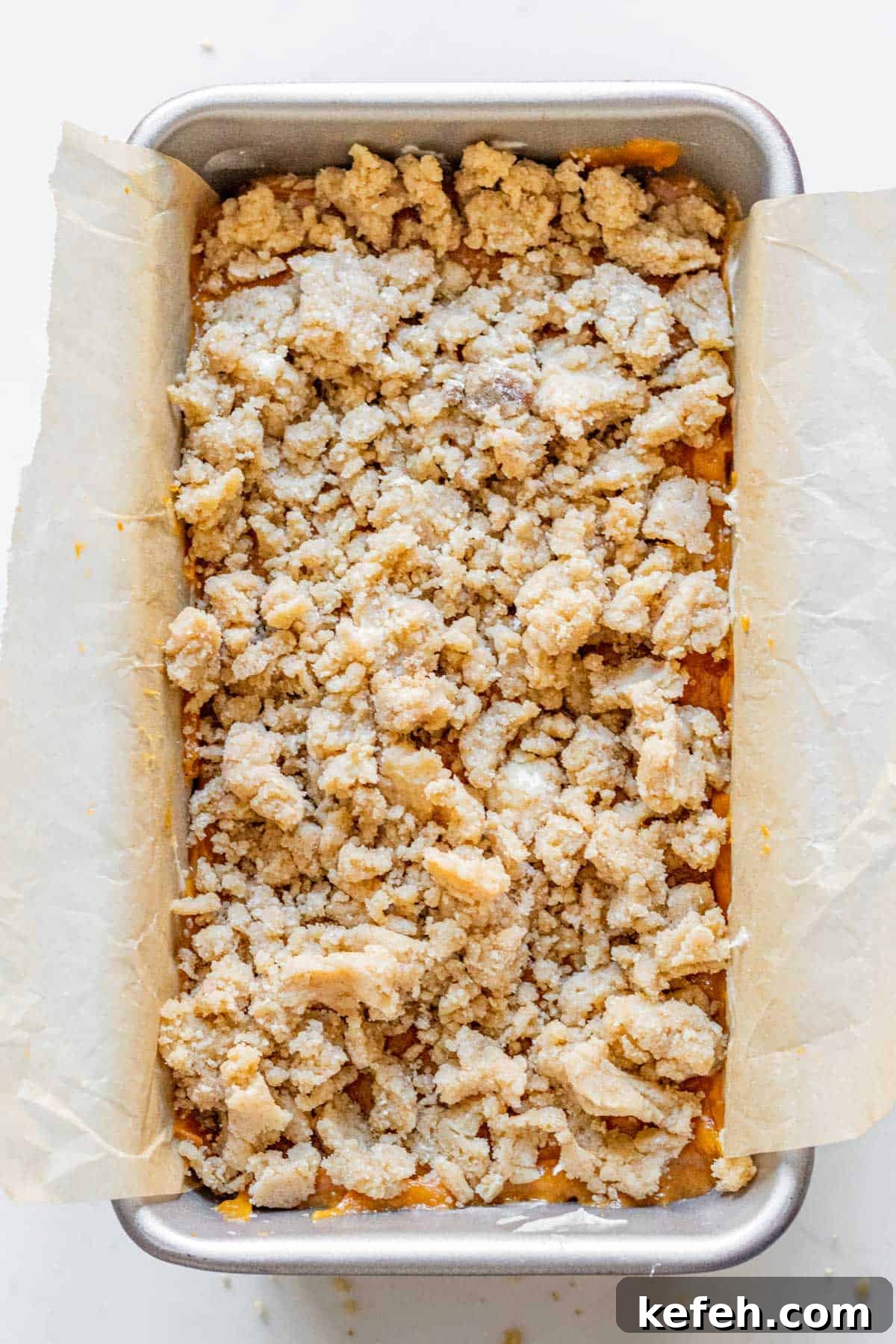 pumpkin bread batter with a streusel topping in a loaf pan