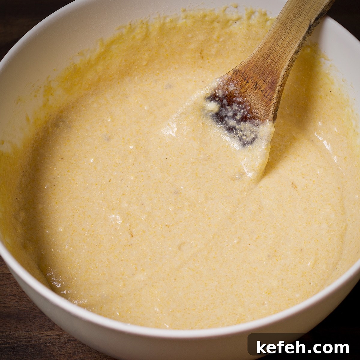 Stir the wet ingredients into the dry ingredients with a wooden spoon.