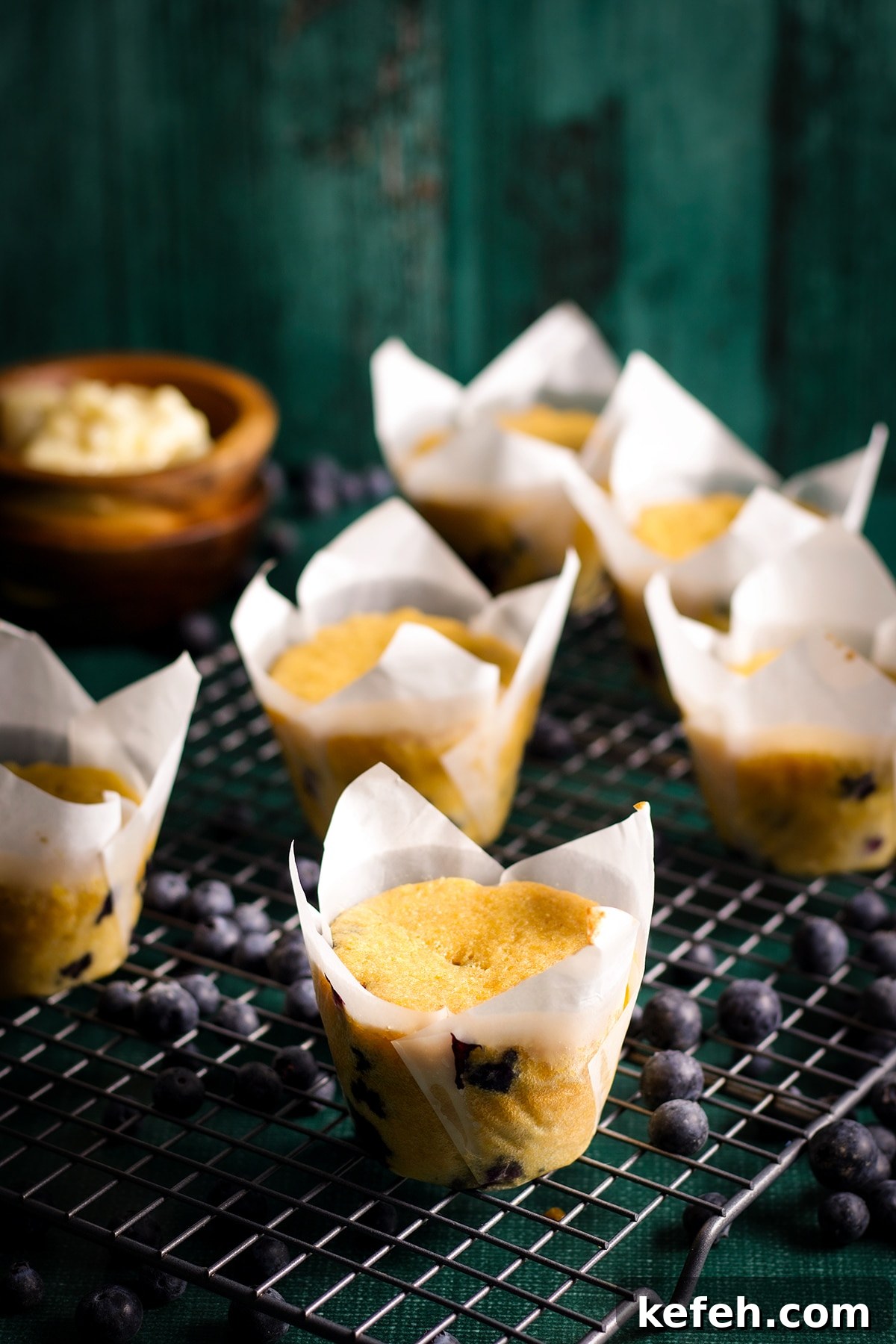 Blueberry corn muffins cooling on a wire baking rack.