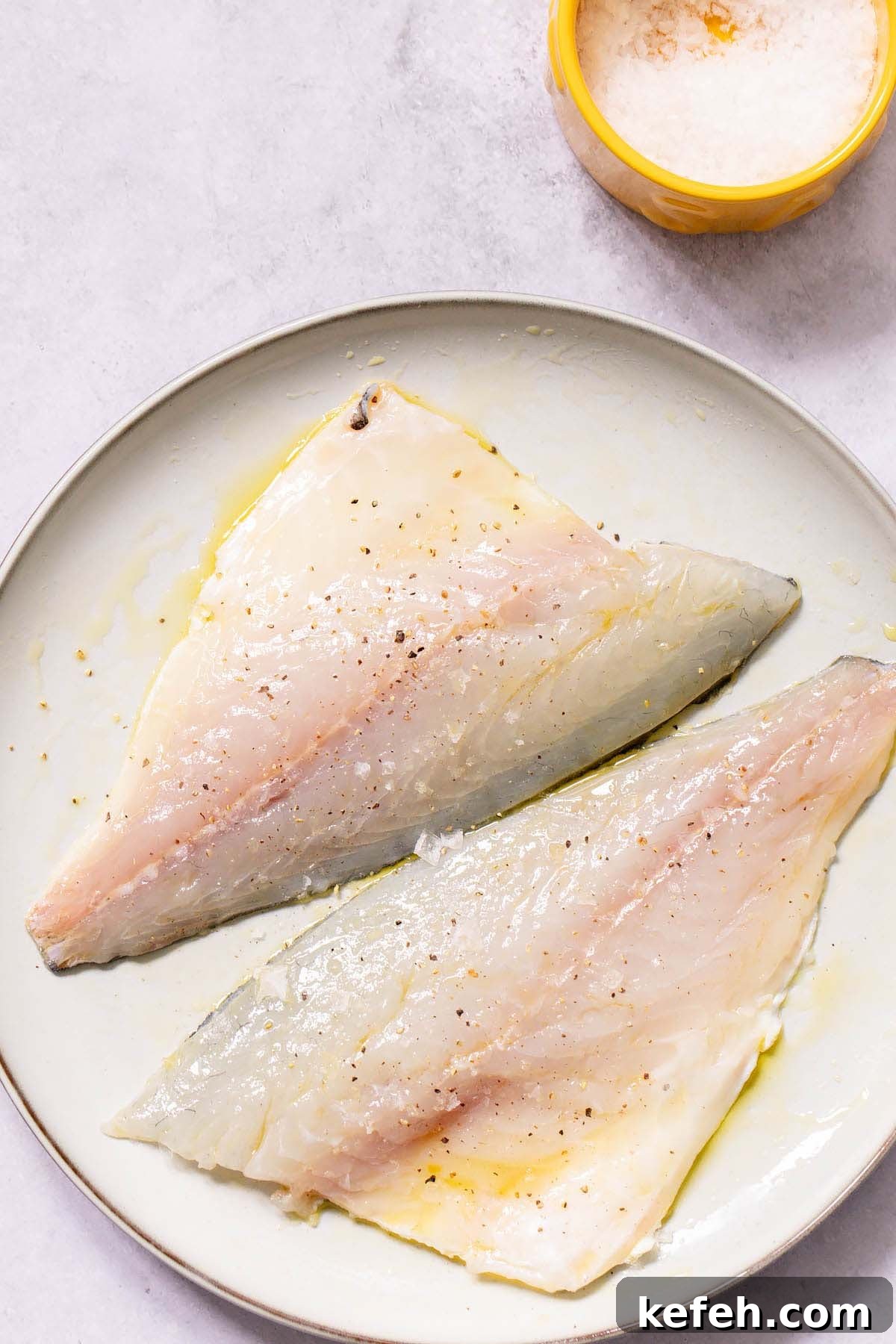 Crispy Air-Fryer Sea Bream Fillets with Lemon 4 Salt and pepper on raw sea bream fillets