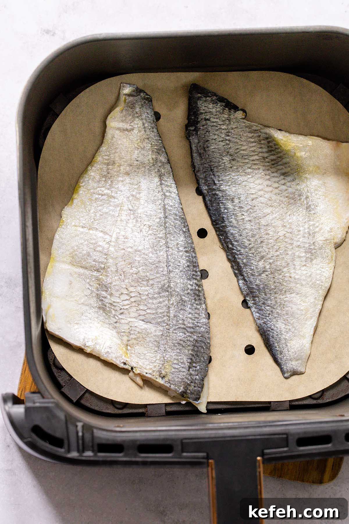 Crispy Air-Fryer Sea Bream Fillets with Lemon 5 Raw sea bream fillets in air fryer basket
