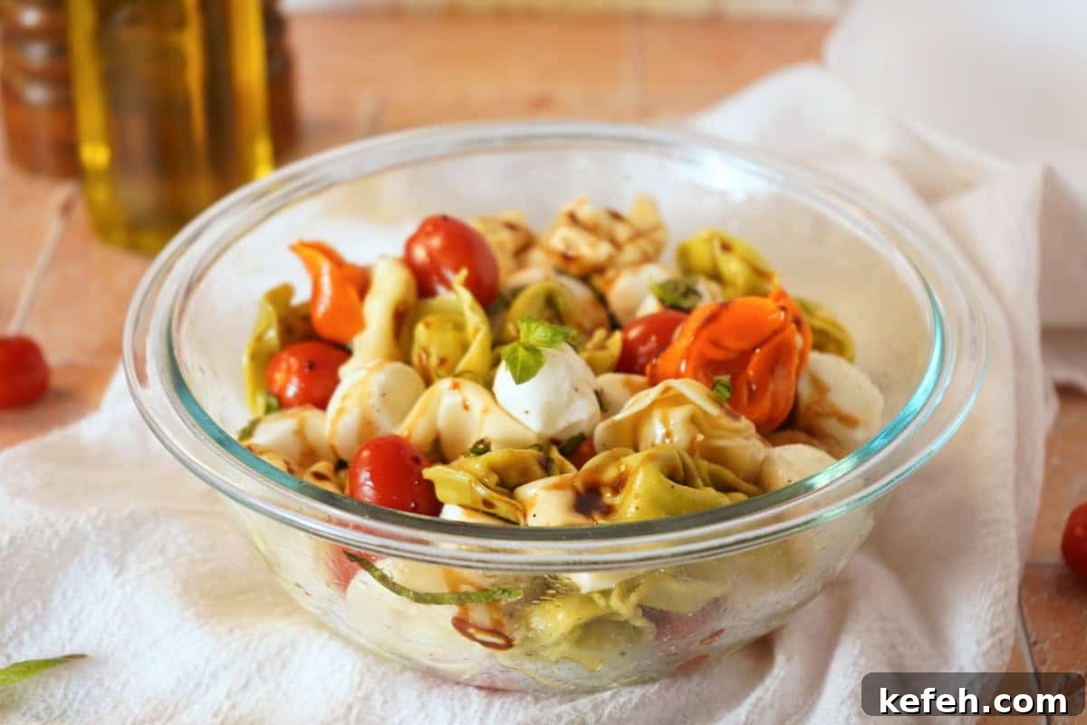 Caprese Tortellini Pasta Salad with Cherry Tomatoes & Basil 3 caprese pasta salad close up with olive oil in background