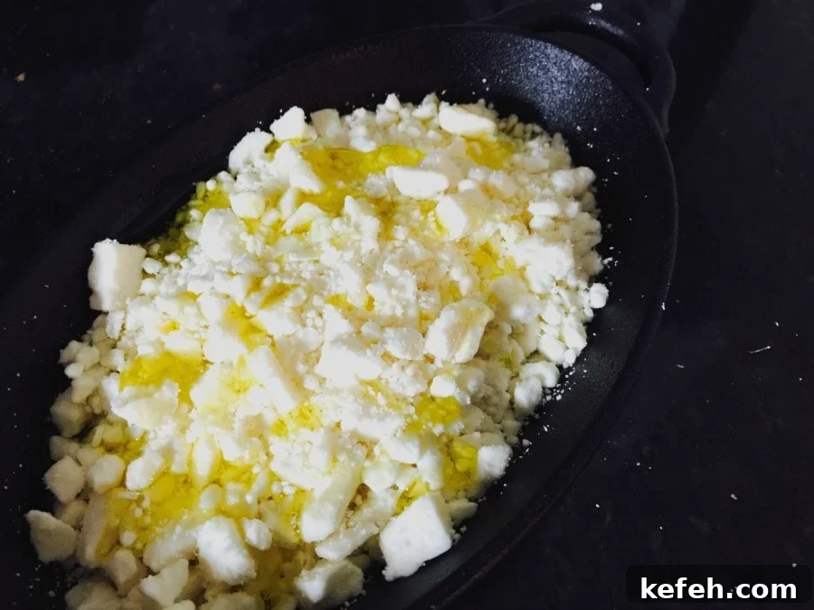 Honey-Roasted Feta Dip with Warm Honey and Crispy Herbs 4 Feta cheese topped with olive oil in a cast iron pan