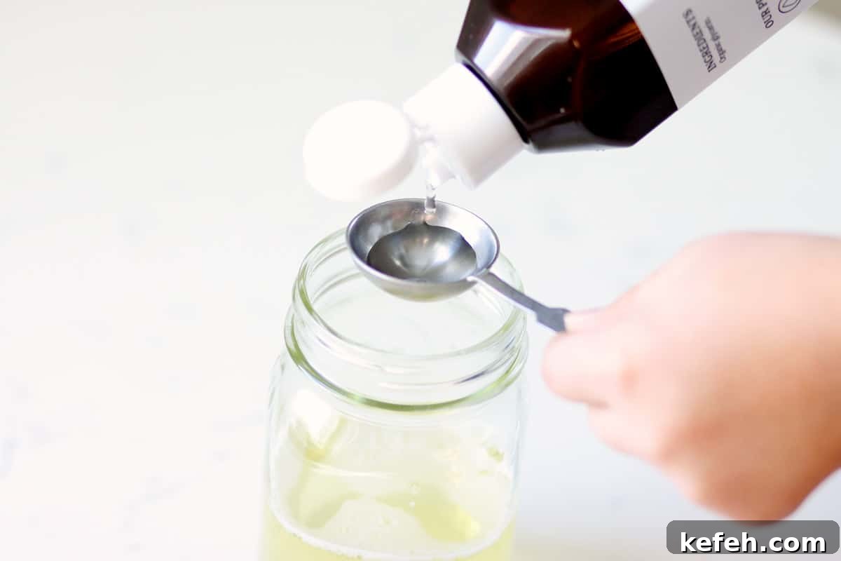 Homemade Baby Wash: Gentle DIY Recipe for Sensitive Skin 3 vegetable glycerin being poured into a mason jar with castile soap in it