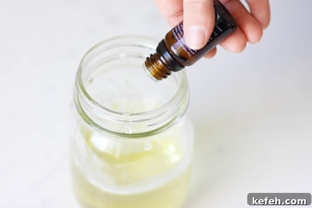 Homemade Baby Wash: Gentle DIY Recipe for Sensitive Skin 4 an essential oil being poured into a mason jar with castile soap
