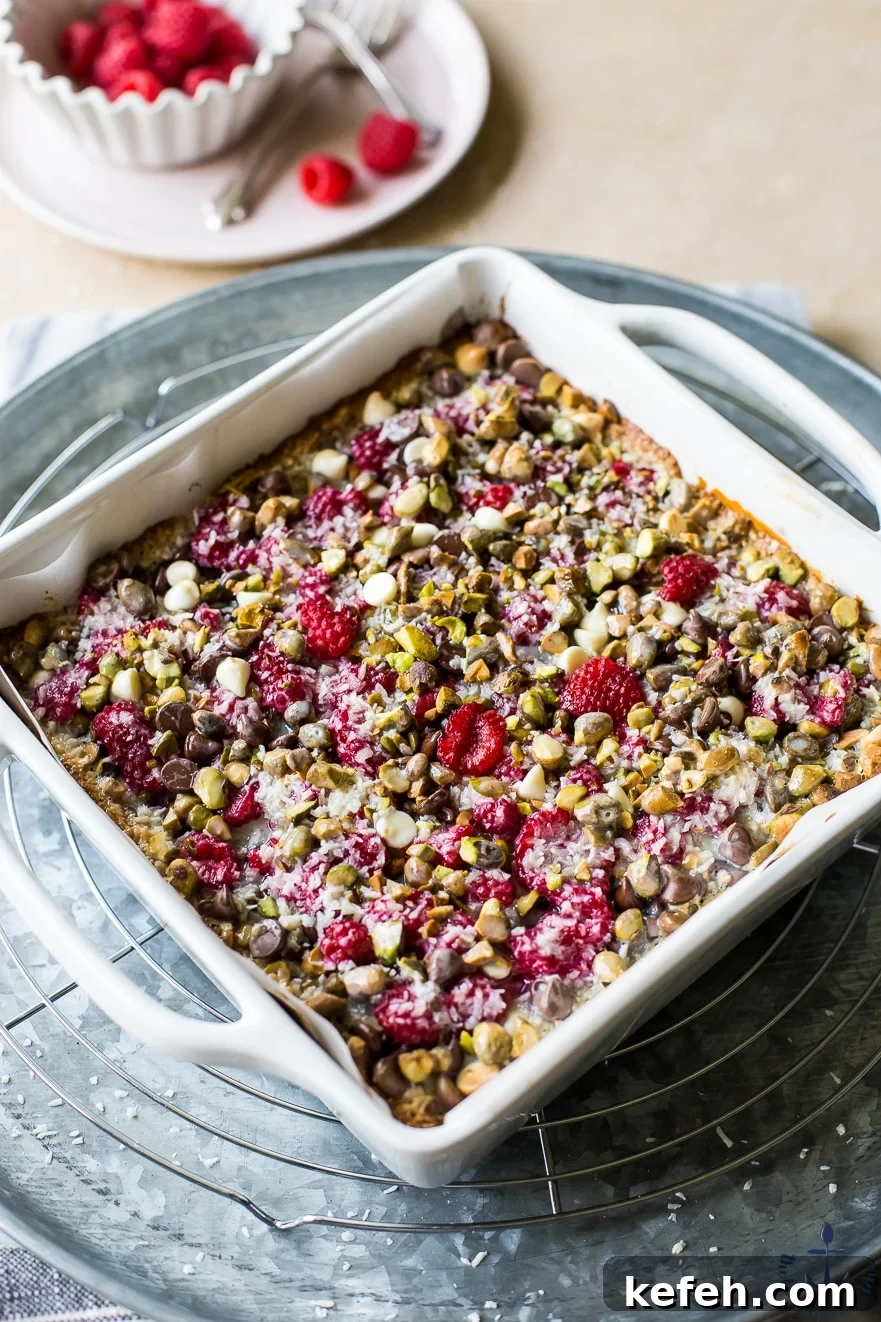 Photo of raspberry pistachio magic bars in white pan