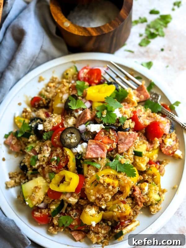 10-Minute Creamy Cheesy Ramen 6 Italian Quinoa Salad on a white plate with a silver fork.