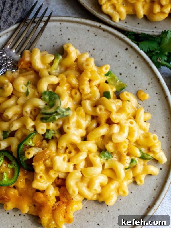 10-Minute Creamy Cheesy Ramen 9 Cheesy noodles on a plate with a silver fork