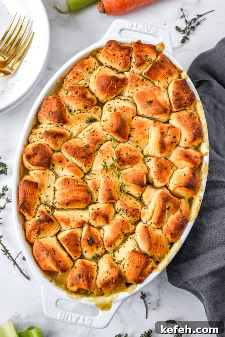 Chicken pot pie with biscuit crush in a white oval serving dish.