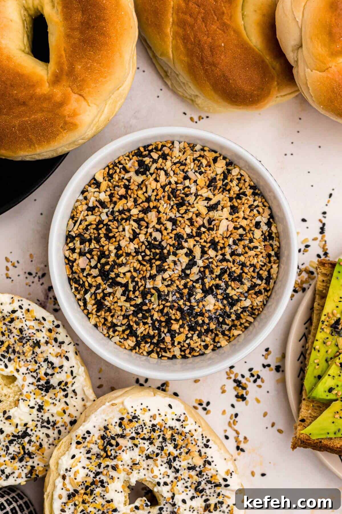 Everything Bagel Seasoning in a small bowl surrounded by bagels and avocado toast.