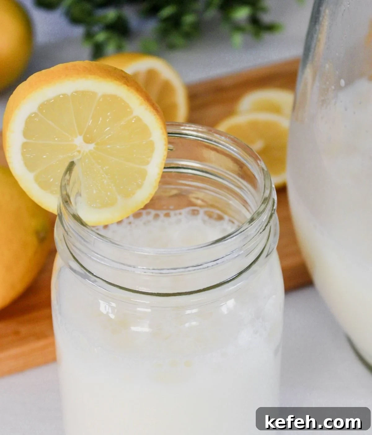 Mason jar with creamy lemonade with a lemon on the side.