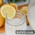 Mason jar glass of creamy lemonade drink with a lemon slice on the side.