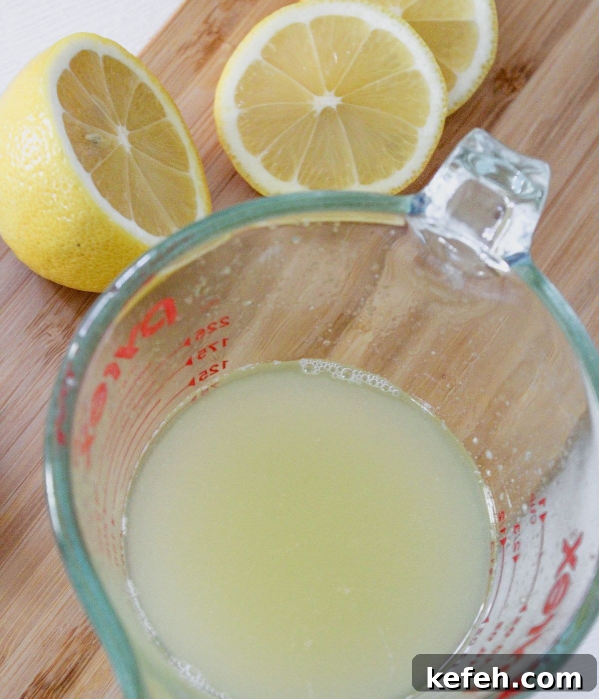Measuring cup with lemon juice in it.