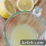 Measuring cup with lemon juice in it.