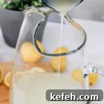 Pitcher of lemon juice and water, pouring sweetened condensed milk into pitcher.
