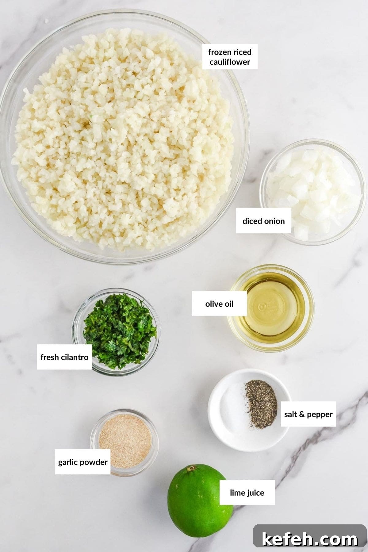 Cilantro Lime Cauliflower Rice Recipe for Flavorful Low-Carb Sides 3 Overhead view of ingredients for a recipe on a marble countertop, including riced cauliflower, diced onion, cilantro, olive oil, garlic powder, salt, pepper, and lime juice, with labels.